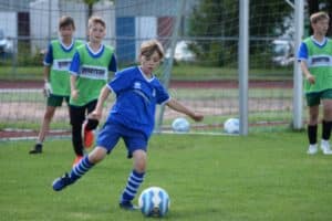 Junge dribbelt mit dem Fußball